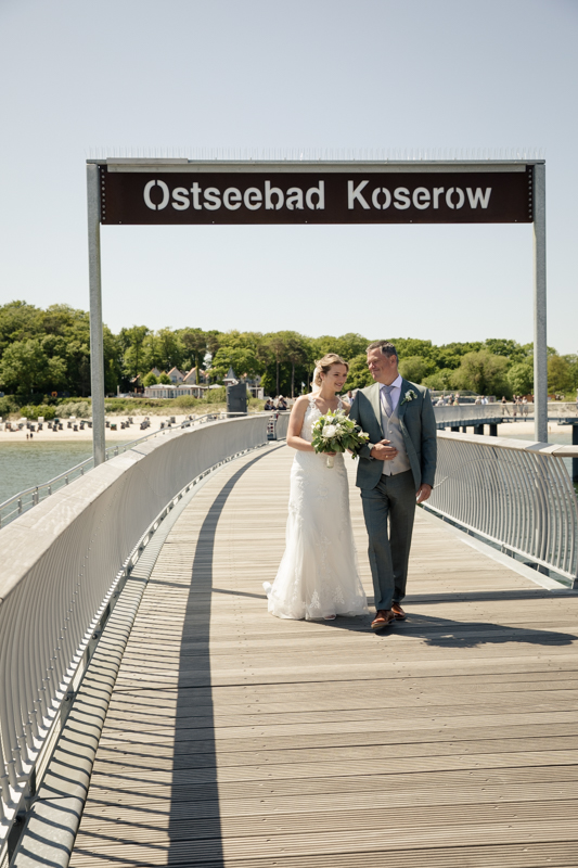 Brautvater führt Braut auf der Seebrücke in Koserow zum Altar